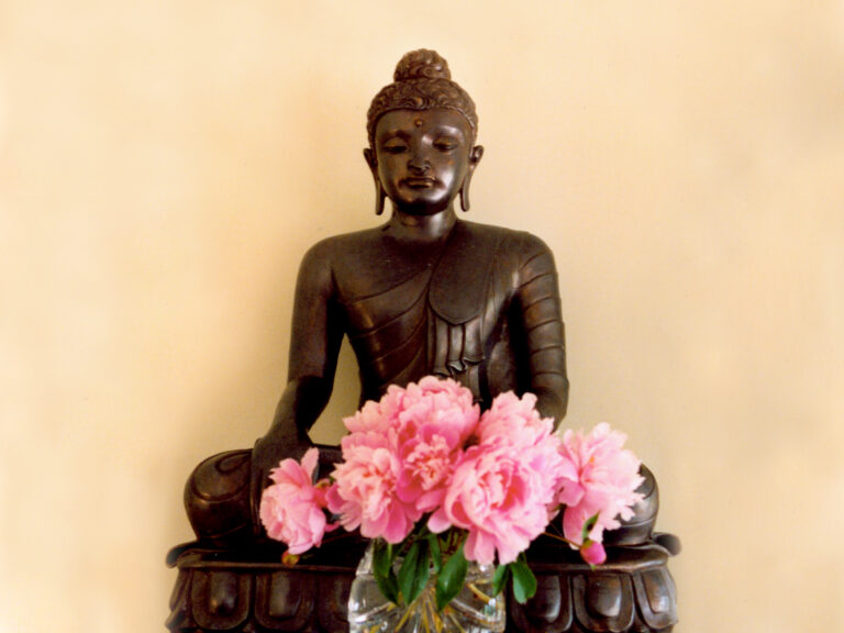 Buddha statue with pink flowers