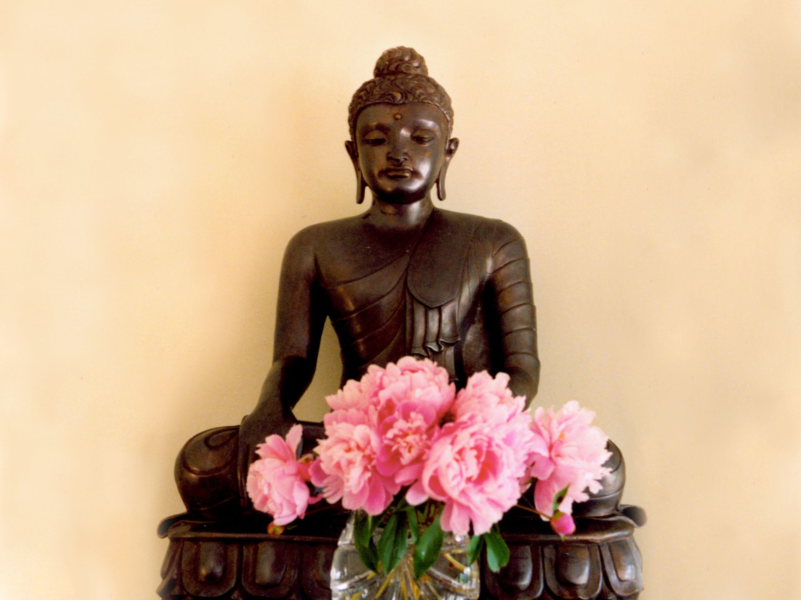 Buddha statue with pink flowers